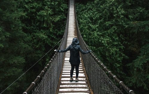 person walking across bridge