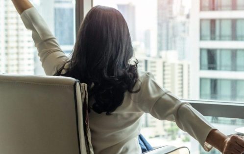 woman stretching with a cup of tea