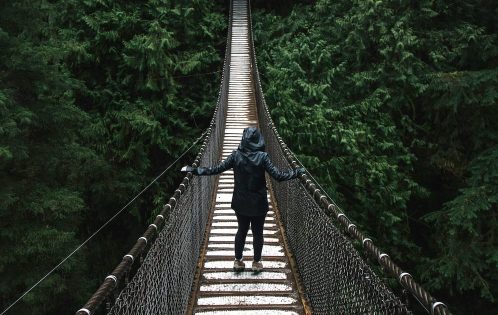 person walking across bridge