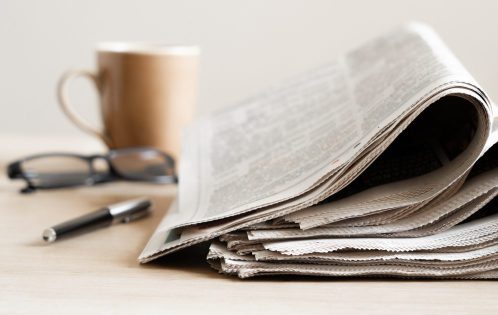 Pile of newspapers stacks on table