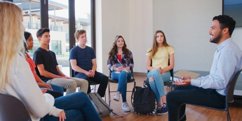 students and instructor sitting in circle