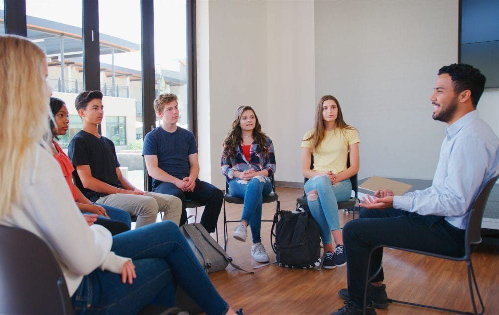 students and instructor sitting in circle